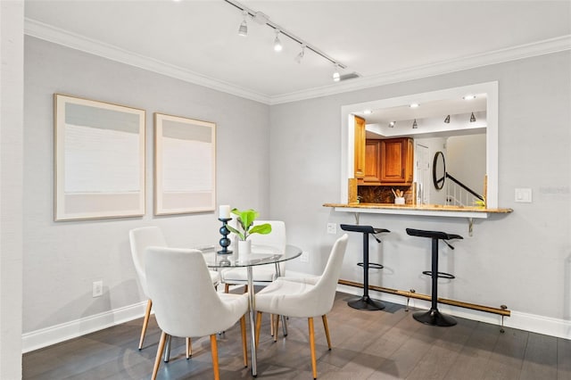 dining space featuring ornamental molding, dark wood-style flooring, and baseboards