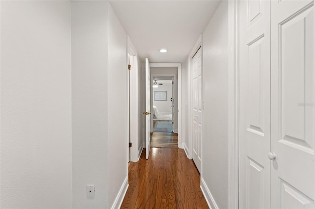 hall with baseboards, dark wood finished floors, and recessed lighting