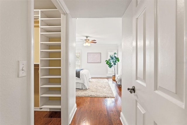 hallway featuring baseboards and wood finished floors