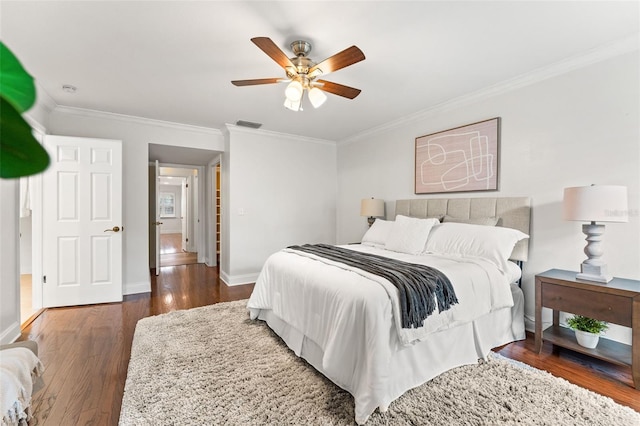 bedroom with visible vents, baseboards, a ceiling fan, dark wood finished floors, and crown molding