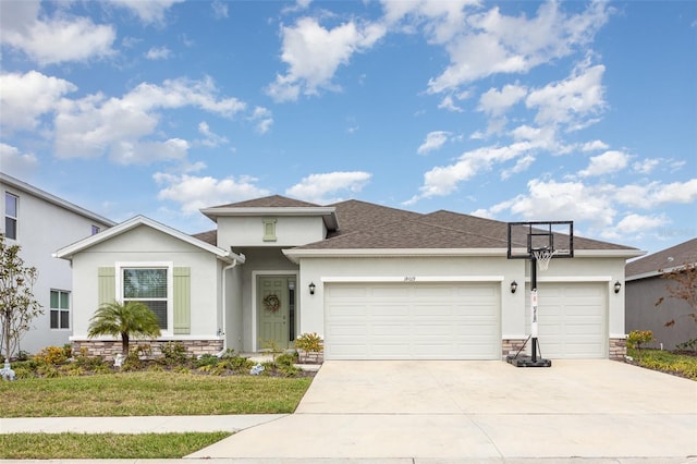 view of front of house featuring an attached garage, stone siding, concrete driveway, and stucco siding