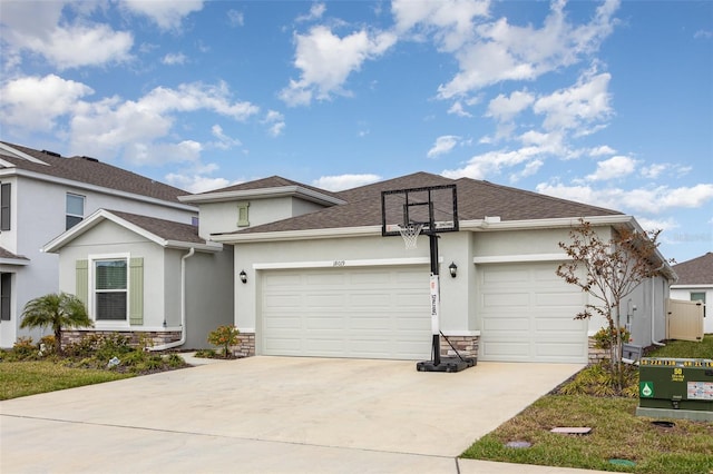 view of front of property with an attached garage, stone siding, and stucco siding