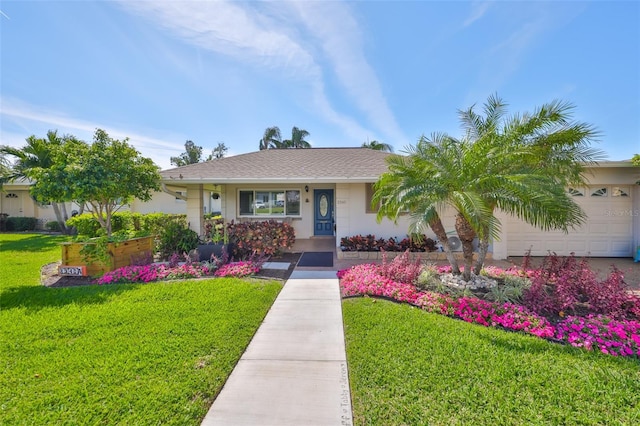 ranch-style house featuring a front yard, an attached garage, and stucco siding