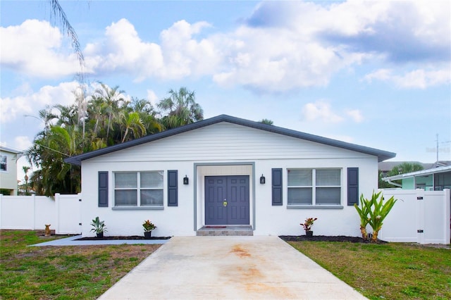 bungalow-style house with a front lawn and fence