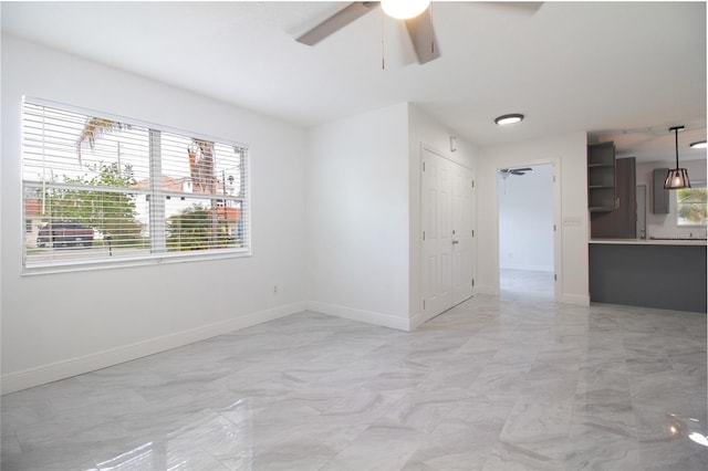 unfurnished room with baseboards and a ceiling fan