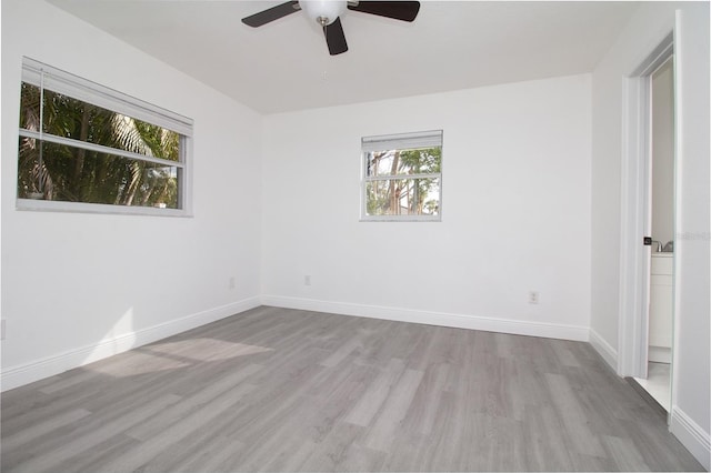 empty room featuring baseboards and light wood finished floors