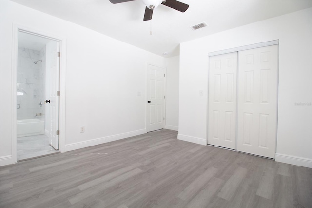 unfurnished bedroom with light wood-style floors, baseboards, visible vents, and a closet