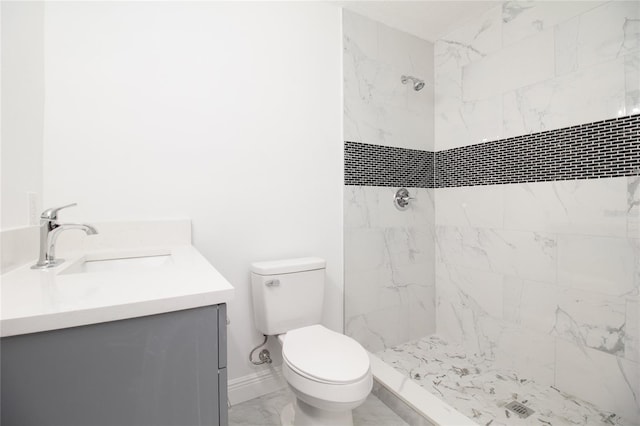 bathroom featuring toilet, vanity, baseboards, marble finish floor, and a stall shower