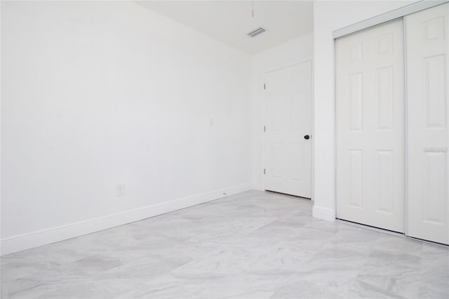 unfurnished bedroom featuring a closet, visible vents, and baseboards