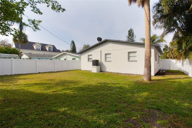 back of house featuring cooling unit, a fenced backyard, and a lawn