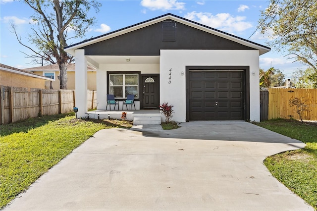 view of front of house with an attached garage, covered porch, fence, driveway, and stucco siding