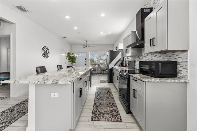 4440 58th Ave N, Saint Petersburg, FL 33714 - kitchen with visible vents, a kitchen breakfast bar, a kitchen island with sink, gray cabinets, and black appliances