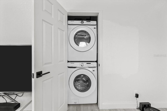 4440 58th Ave N, Saint Petersburg, FL 33714 - washroom with laundry area, stacked washer / dryer, and light wood-style flooring