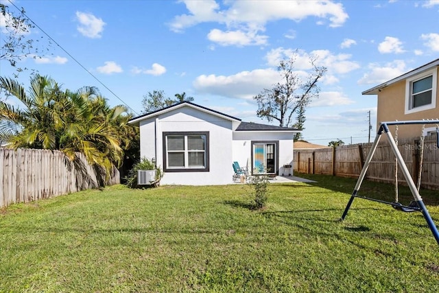 4440 58th Ave N, Saint Petersburg, FL 33714 - rear view of house featuring a fenced backyard, a lawn, a playground, and stucco siding