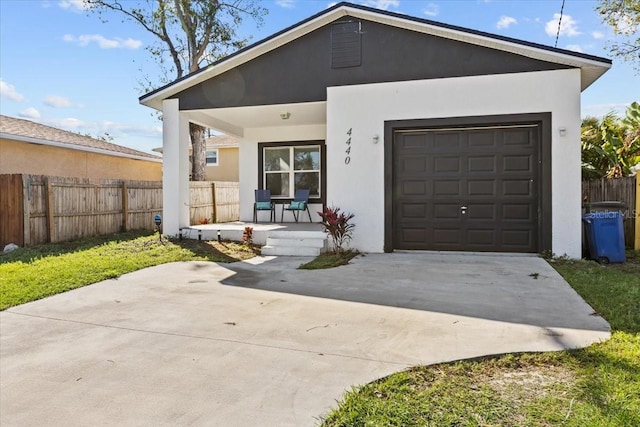4440 58th Ave N, Saint Petersburg, FL 33714 - view of front of property with a garage, concrete driveway, fence, and stucco siding