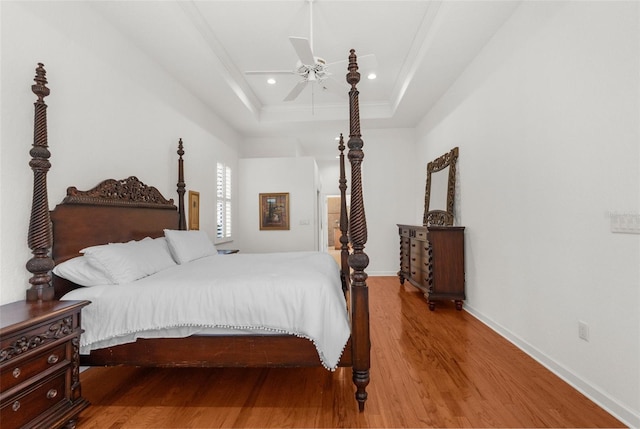 bedroom with ceiling fan, recessed lighting, wood finished floors, baseboards, and a raised ceiling