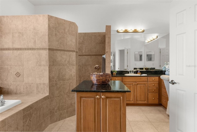 full bathroom featuring tiled tub, vanity, and tile patterned floors