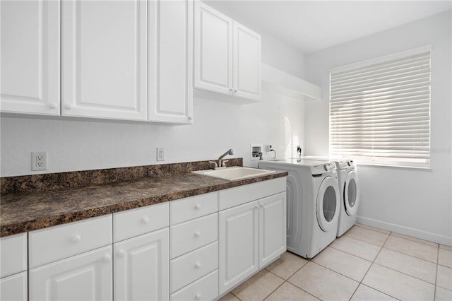 laundry room featuring cabinet space, light tile patterned floors, baseboards, washer and dryer, and a sink