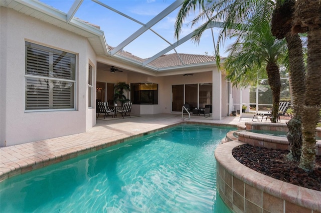 view of swimming pool featuring a pool with connected hot tub, a lanai, a patio area, and ceiling fan