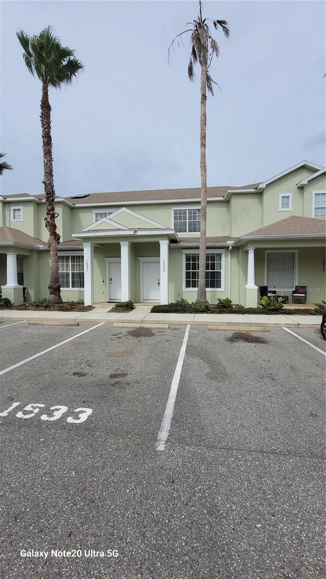 view of front facade featuring uncovered parking and stucco siding