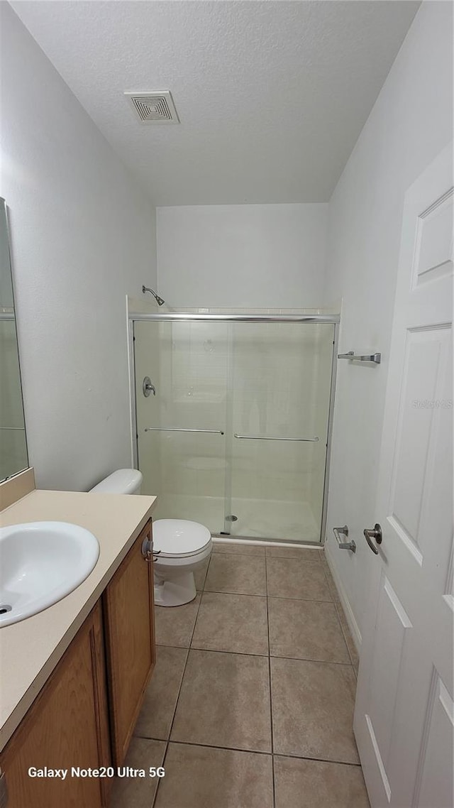 full bath with visible vents, toilet, tile patterned floors, vanity, and a shower stall