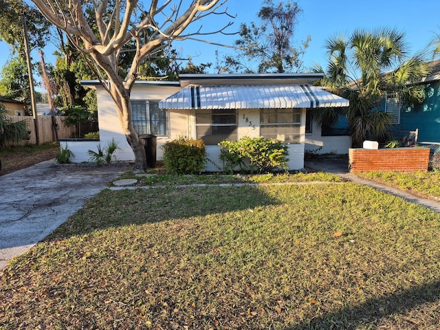 bungalow with fence and a front lawn