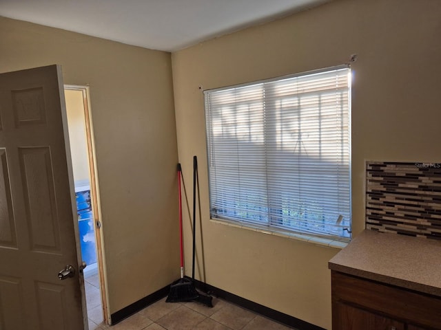 unfurnished room featuring baseboards and light tile patterned flooring