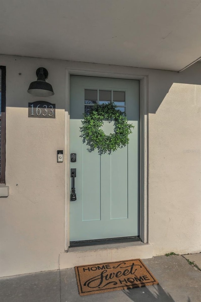 entrance to property featuring stucco siding