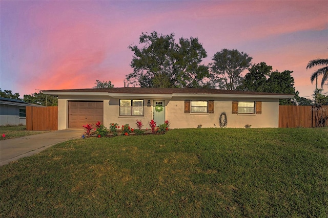 single story home featuring a garage, a front yard, stucco siding, and fence