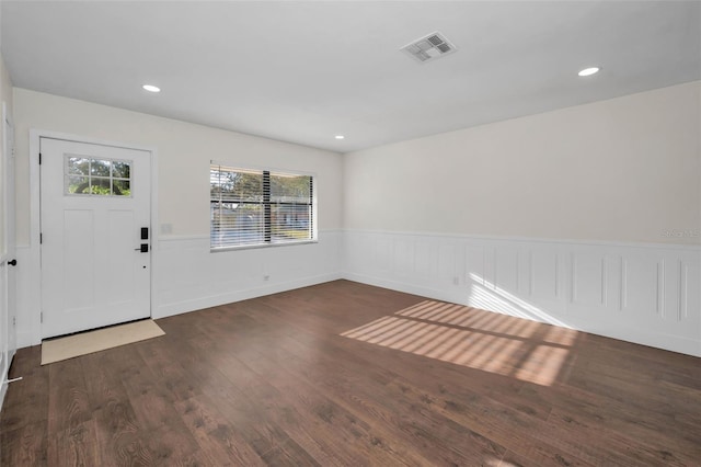 foyer entrance with visible vents, recessed lighting, wood finished floors, and a wainscoted wall