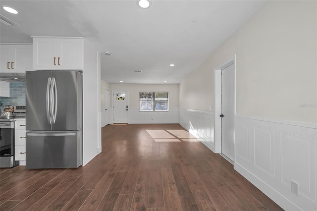 kitchen with dark wood-style floors, decorative backsplash, white cabinets, appliances with stainless steel finishes, and wainscoting