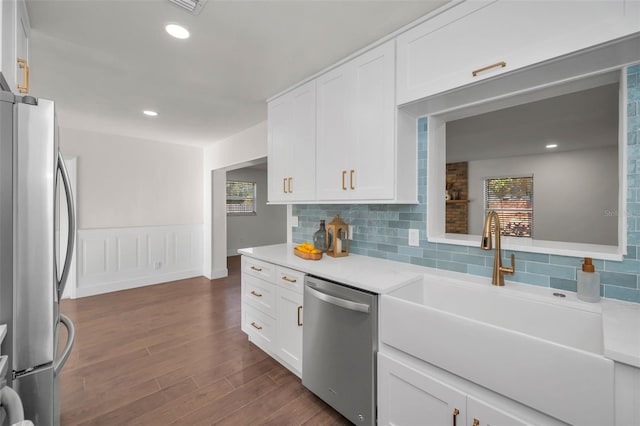 kitchen with a wainscoted wall, appliances with stainless steel finishes, dark wood finished floors, and white cabinetry