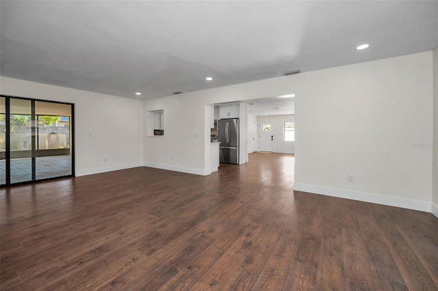 unfurnished living room featuring visible vents, recessed lighting, baseboards, and dark wood-style flooring