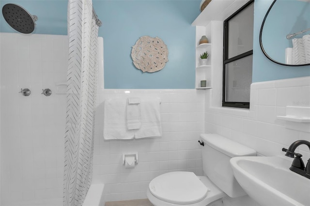 full bathroom with tile walls, toilet, tiled shower, and a sink