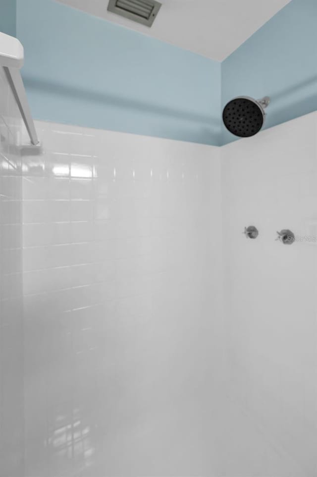 details with visible vents and a tile shower