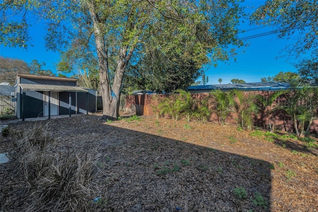 view of yard with an outdoor structure and fence