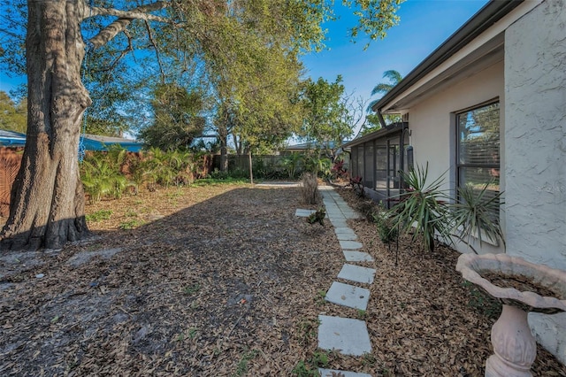 view of yard featuring fence and a sunroom