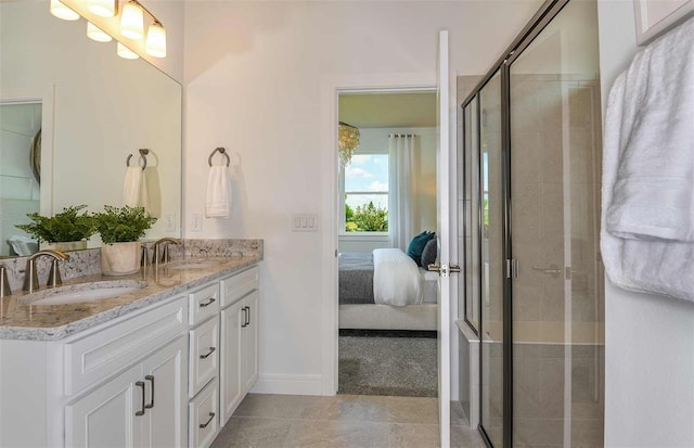 ensuite bathroom with double vanity, a shower stall, ensuite bathroom, and a sink