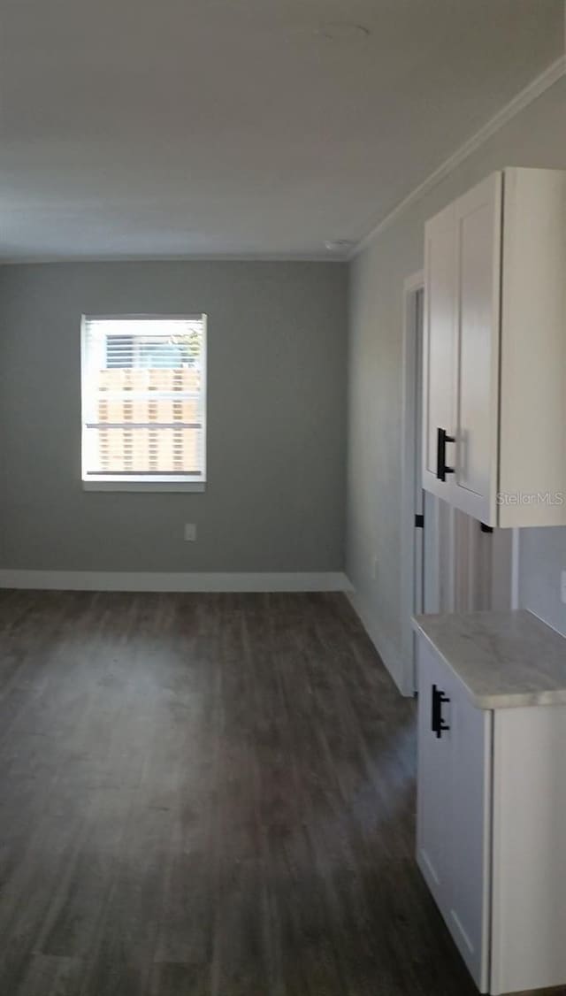 spare room with dark wood-style floors and baseboards