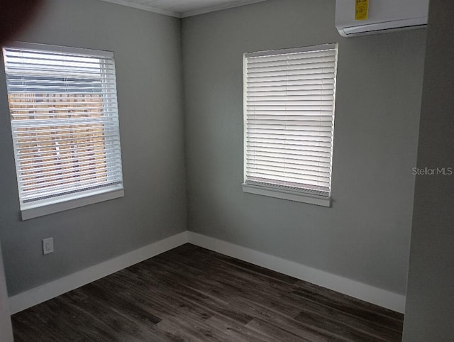 spare room featuring dark wood finished floors, baseboards, and a wall mounted AC