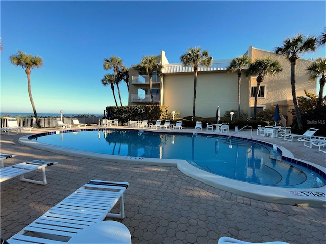 community pool featuring fence and a patio