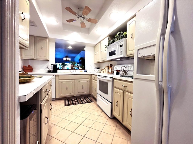 kitchen featuring light tile patterned floors, white appliances, a sink, light countertops, and a raised ceiling