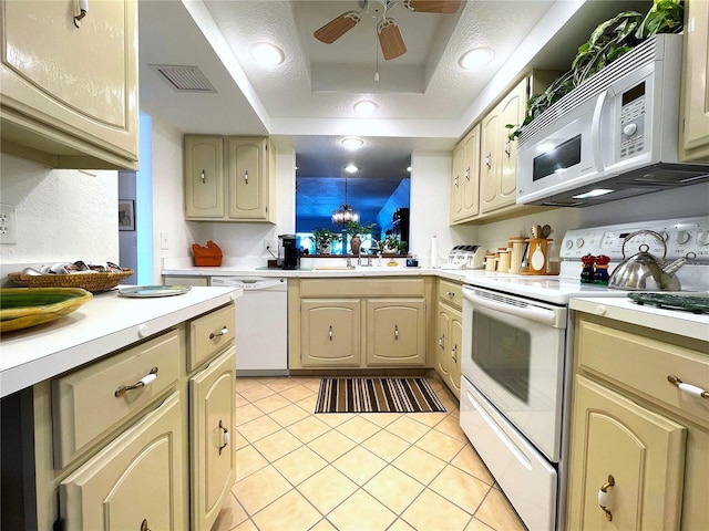 kitchen with light tile patterned floors, white appliances, a sink, visible vents, and light countertops