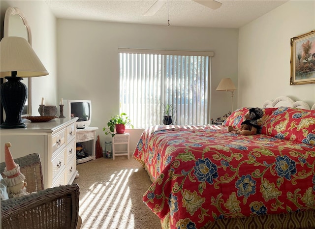 bedroom featuring a textured ceiling, ceiling fan, and light colored carpet