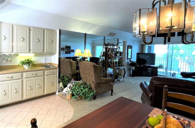 living room featuring a notable chandelier, light tile patterned floors, visible vents, light carpet, and a textured ceiling