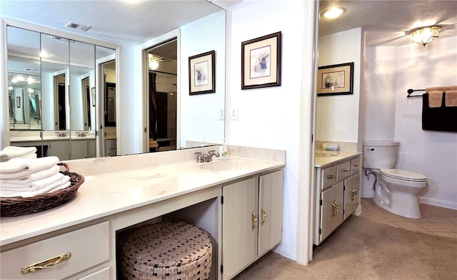 bathroom with toilet, a textured ceiling, vanity, and visible vents