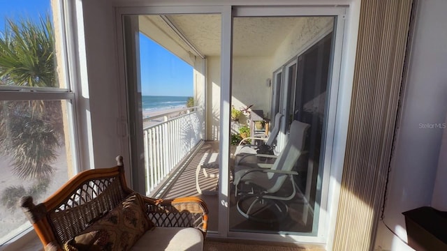 balcony featuring a beach view and a water view