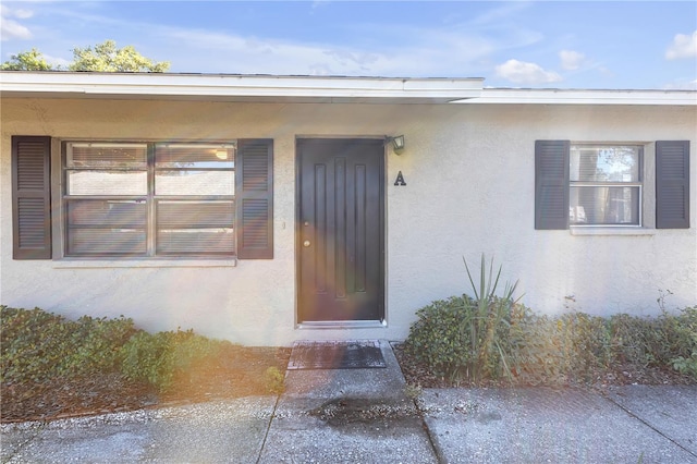 entrance to property featuring stucco siding