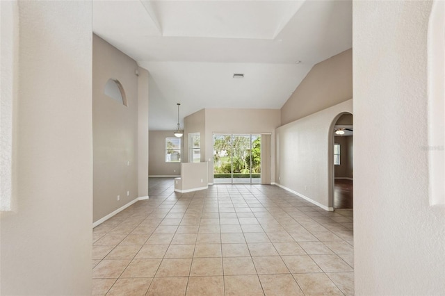 unfurnished room with light tile patterned floors, baseboards, visible vents, arched walkways, and high vaulted ceiling