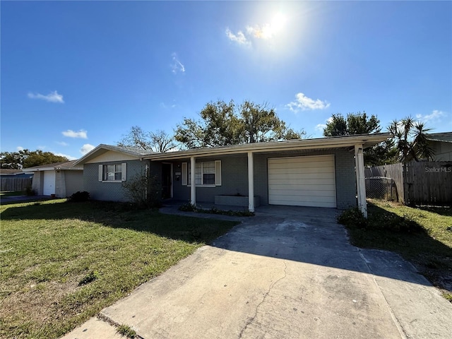 ranch-style home with a garage, driveway, fence, a front yard, and brick siding